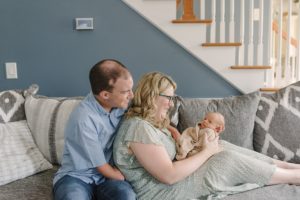 parents play with son on couch during Lifestyle Newborn Session in Nashville