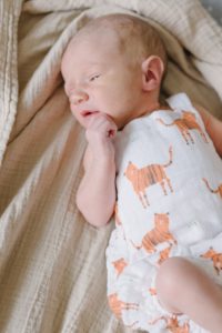 baby in tiger onesie photographed during Lifestyle Newborn Session in Nashville