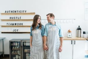 husband and wife hold hands in bakery during Nashville branding photography session