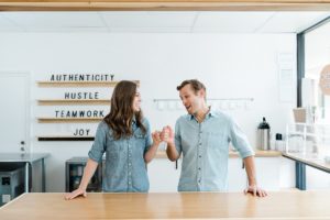 couple fist bumps during Nashville branding photography session in kitchen