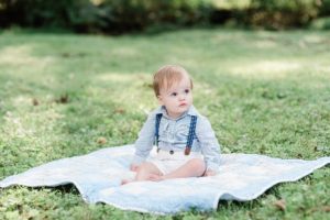 toddler sits on blanket during family photos