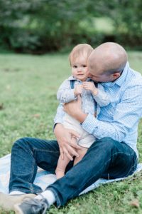 dad plays with toddler during family photos