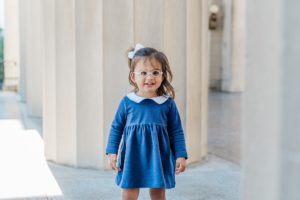 toddler in blue dress smiles during War Memorial fall mini sessions
