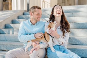 couple laughs together with dog during War Memorial fall mini sessions
