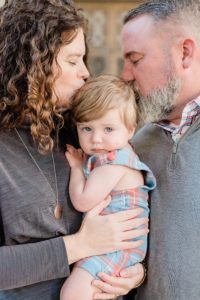 parents kiss toddler during family photos in Nashville TN