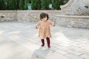 toddler walks on patio at Cheekwood