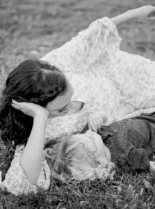 mom lays in grass with son during family photos