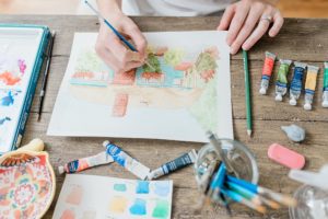 woman paints at wooden table during Nashville branding session