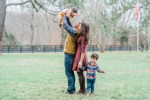 family of four plays during portraits on Nashville farm