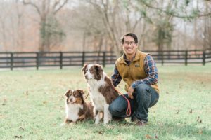 man poses with two Shepard dogs during Nashville extended family portraits
