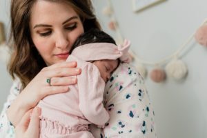mom rocks baby on shoulder during Nashville lifestyle newborn session