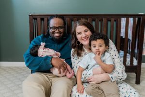 parents hold two children by crib during Nashville lifestyle newborn session
