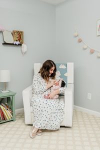 mom feeds baby in nursery during newborn photos at home