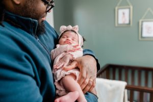 dad looks down at baby girl during Nashville lifestyle newborn session