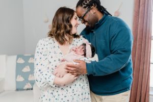 mom and dad stand with noses touching during newborn photos