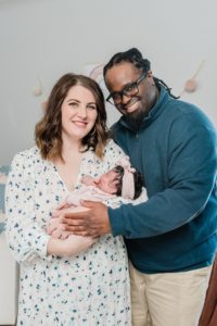 parents hug holding daughter between them during Nashville lifestyle newborn session