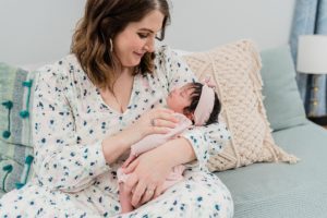 mom holds daughter during at home newborn photos