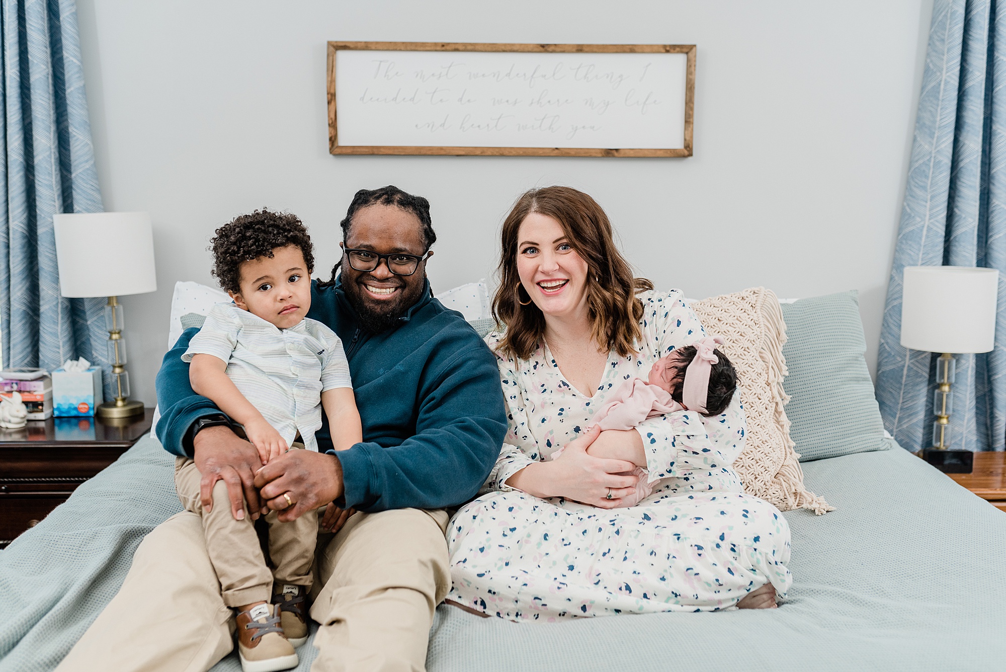 family of four snuggles on bed during Nashville lifestyle newborn session