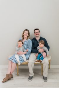 family of four sits on bench in studio during Nashville studio family portraits