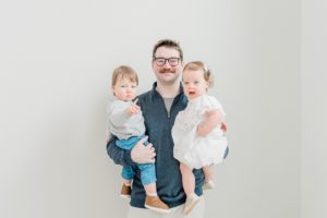 dad holds twin children during studio family photos