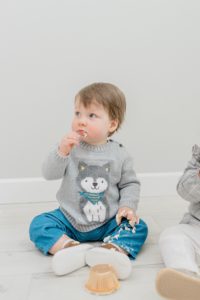 boy eats cupcake during first birthday photos at studio