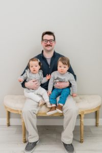 dad sits holding twins during Nashville family photos