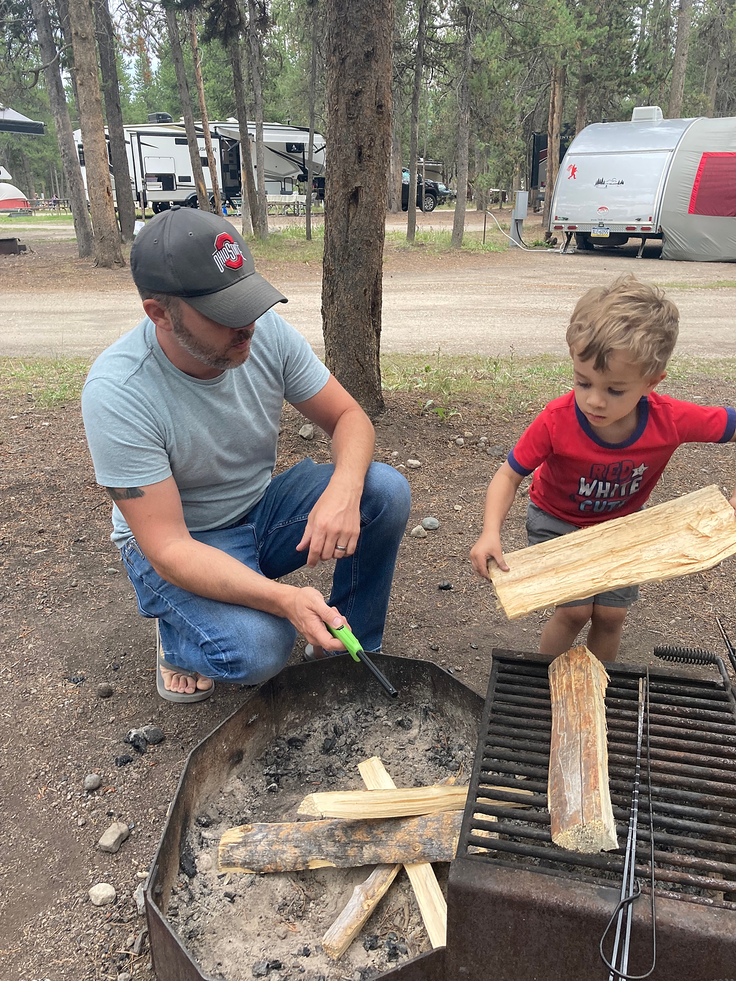 little_boy_helping_his_dad_with_camp_fire