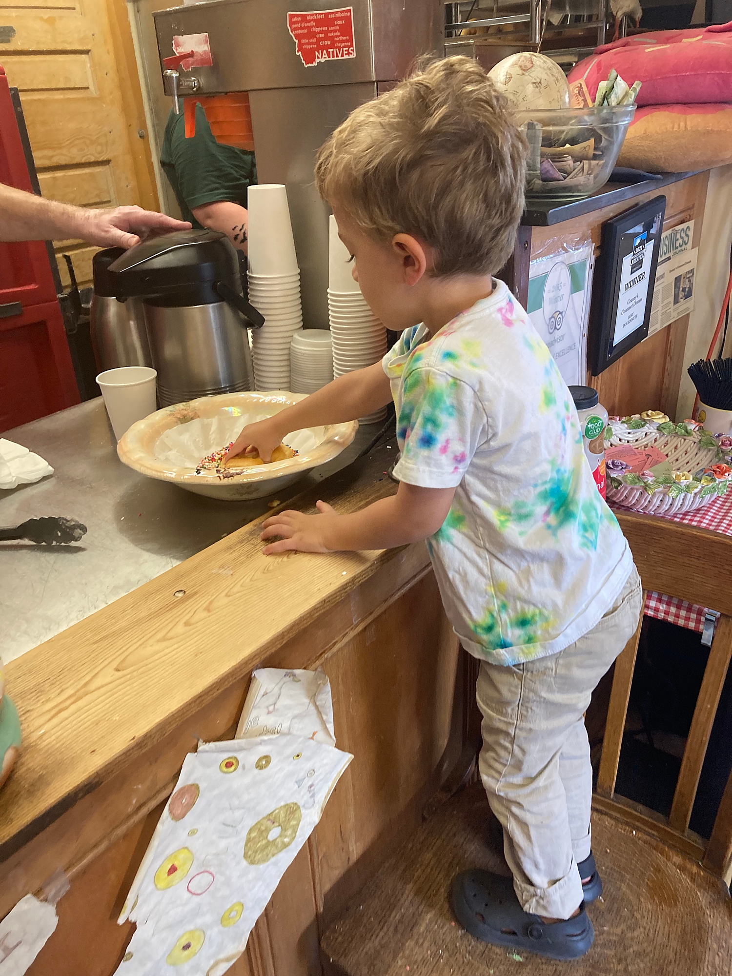 toddler_decorating_donuts_with_sprinkles_at_grannys_donut_shop_in_bozeman_montana