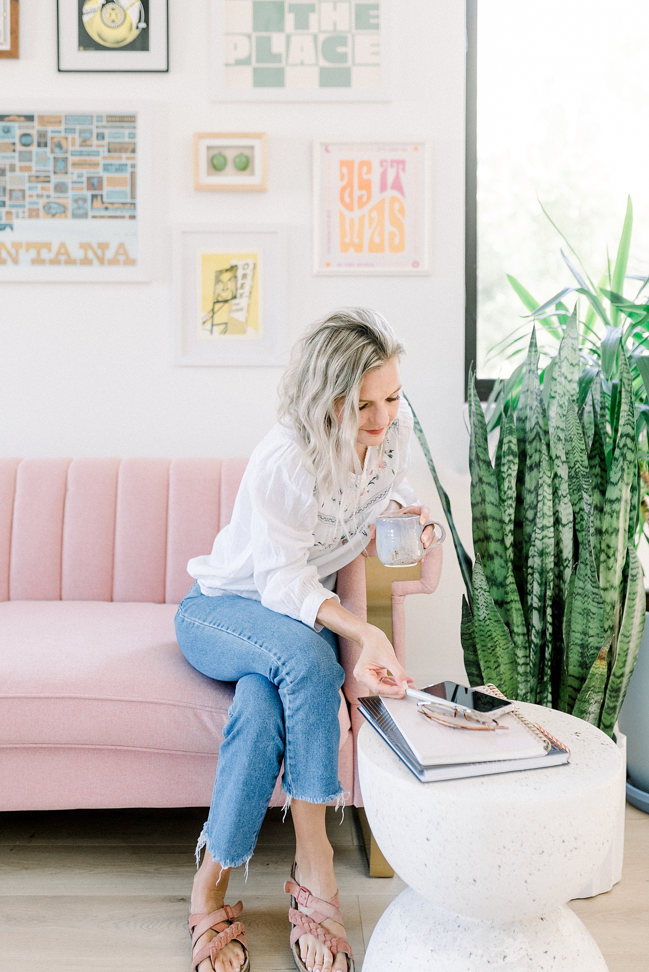 a_woman_sitting_on_pink_couch_holding_a_cup_of_coffee_for_her_branding_session_by_Dolly_DeLong_Photography_in_Bozeman_Montana