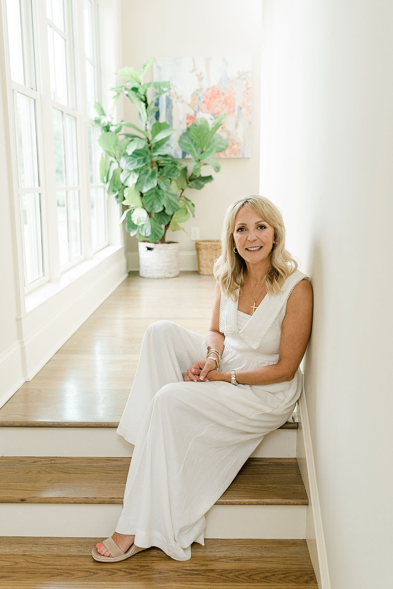 a_middle_aged_woman_is_taking_her_Nashville_branding_photos_for_her_real_estate_business_she_is_wearing_a_white_dress