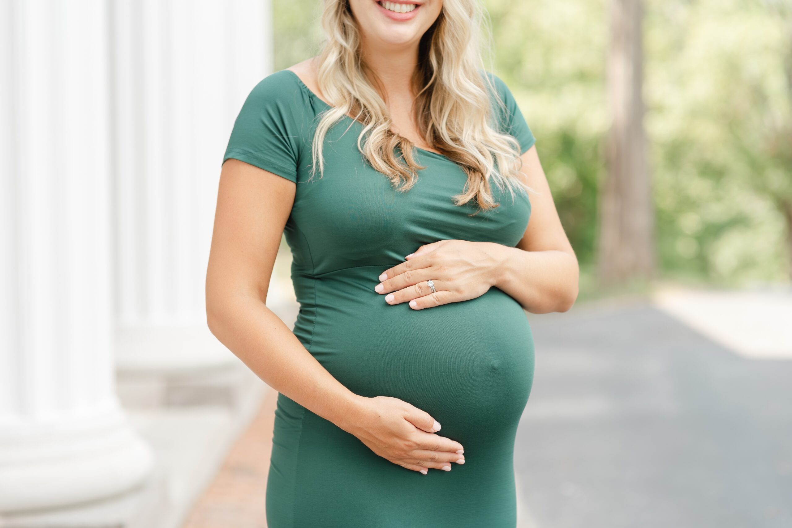 a_pregnant_mom_wearing_a_green_dress_for_maternity_photos_at_Nashville_ellington_ag_center_by_Dolly_DeLong_photography