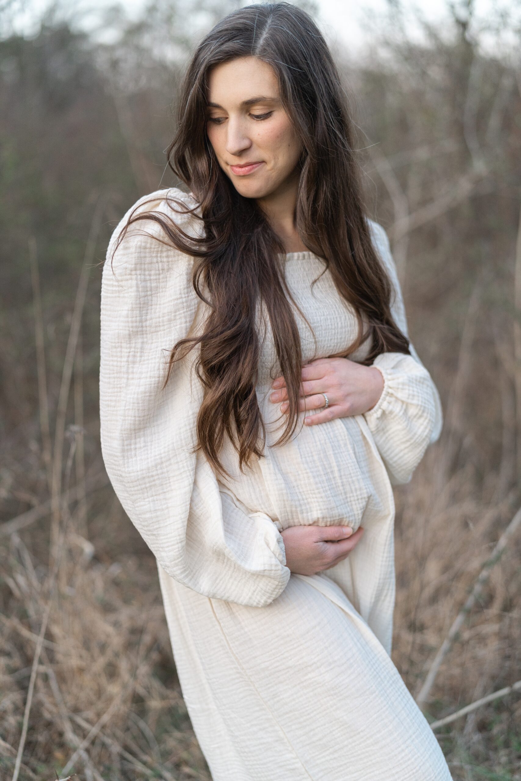 a_pregnant_mom_is_wearing_a_white_nothing_fits_but_maternity_dress_for_her_Maternity_session_in_nashville_with_Nashville_family_photographer_Dolly_DeLong_Photography_spring_maternity_session