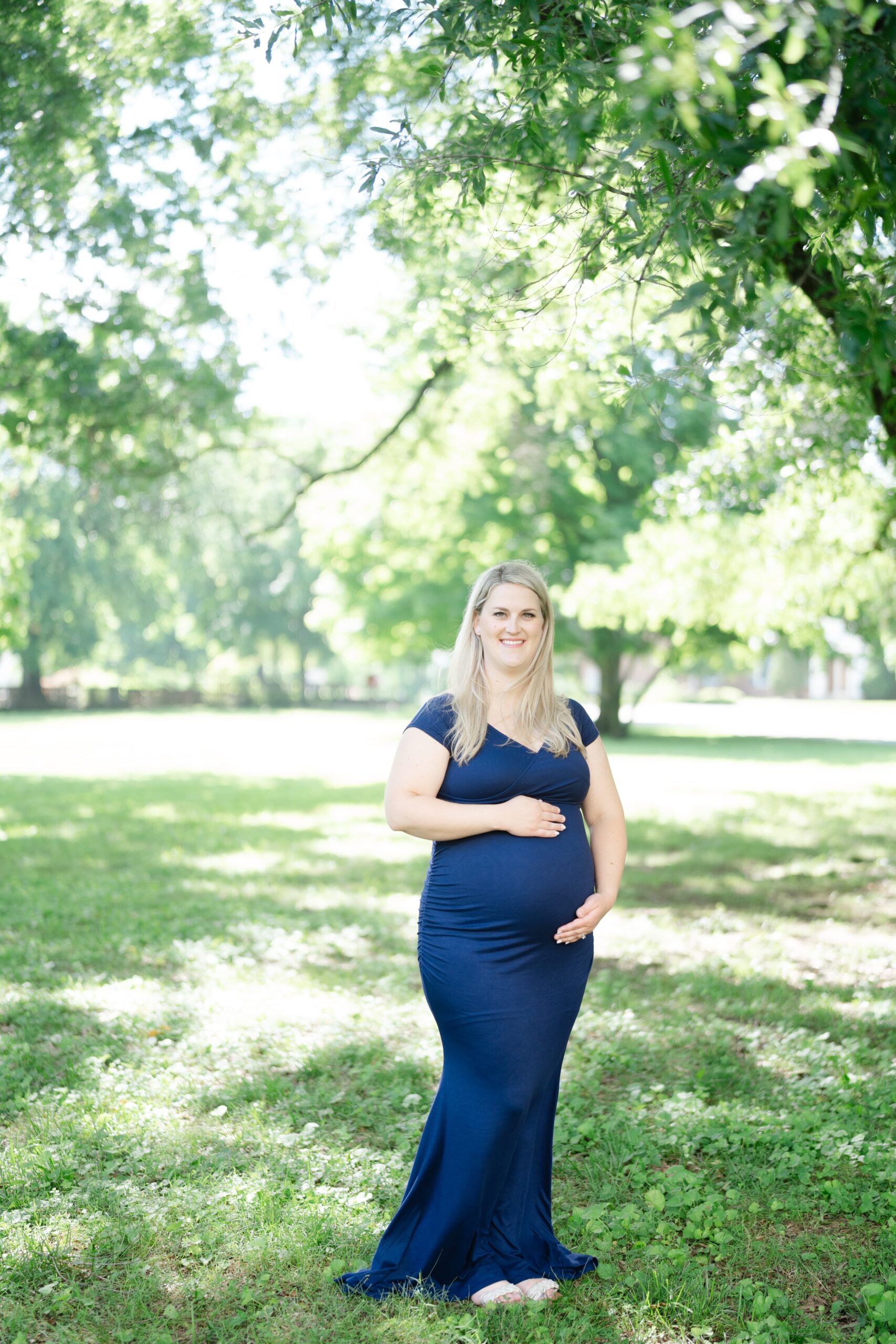 a mother is wearing a navy blue maternity long dress for her maternity photos at the nashville ellington ag center for her maternity photos in nashville
