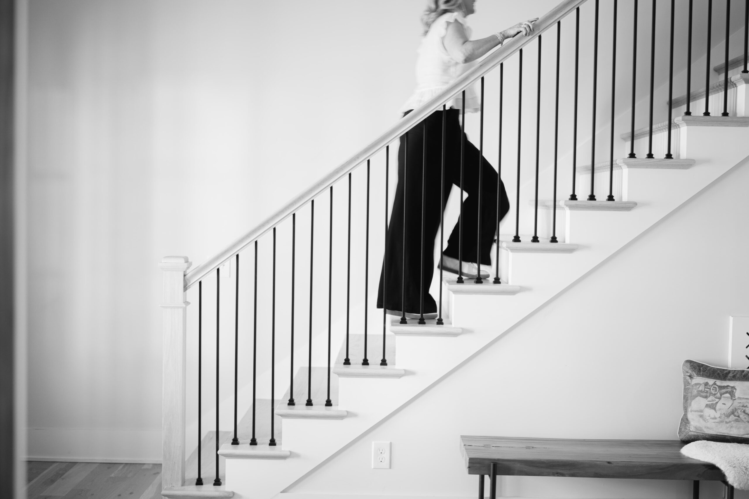 a black and white blurred photo of a woman walking up the stairs for her branding photography session