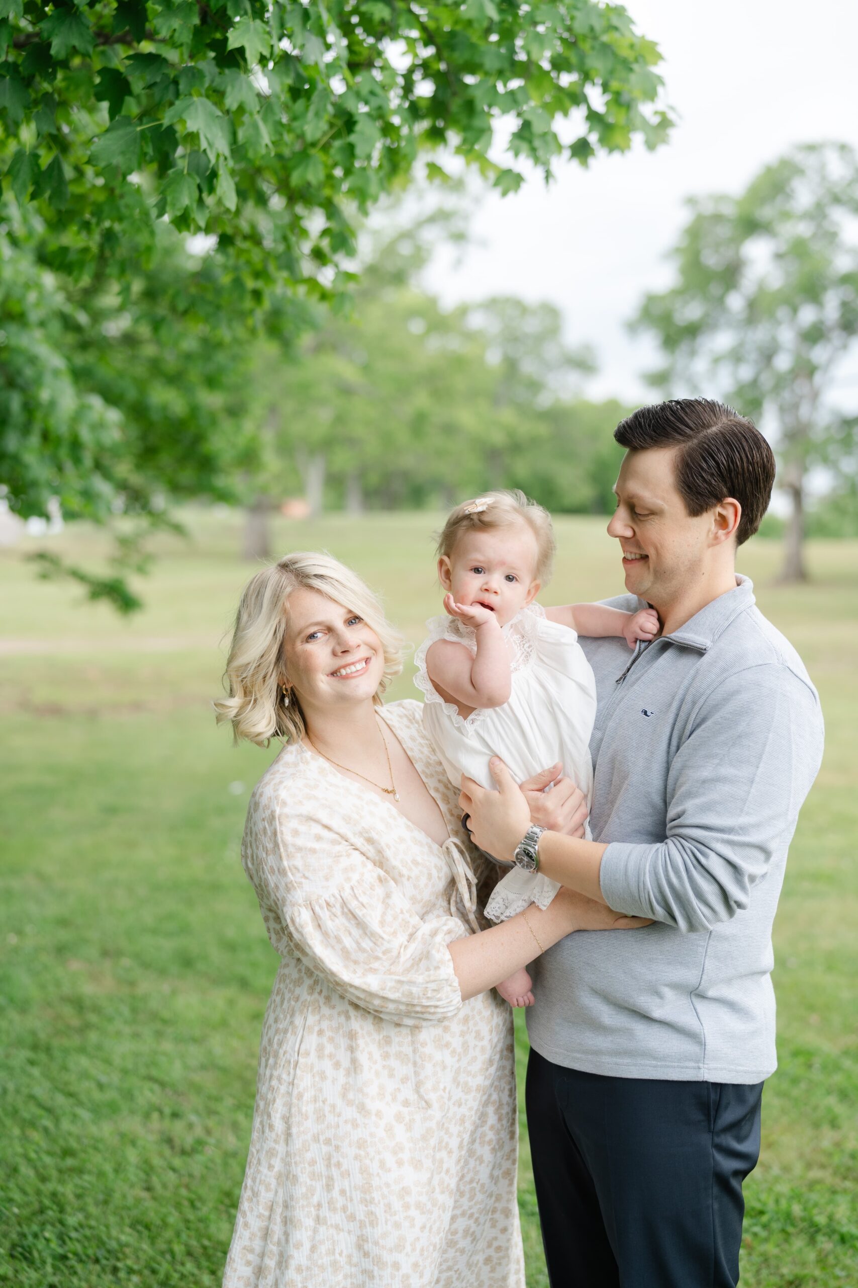 Mom and dad holding their one year old daughter during a family photo session at Ravenswood Mansion in Nashville TN