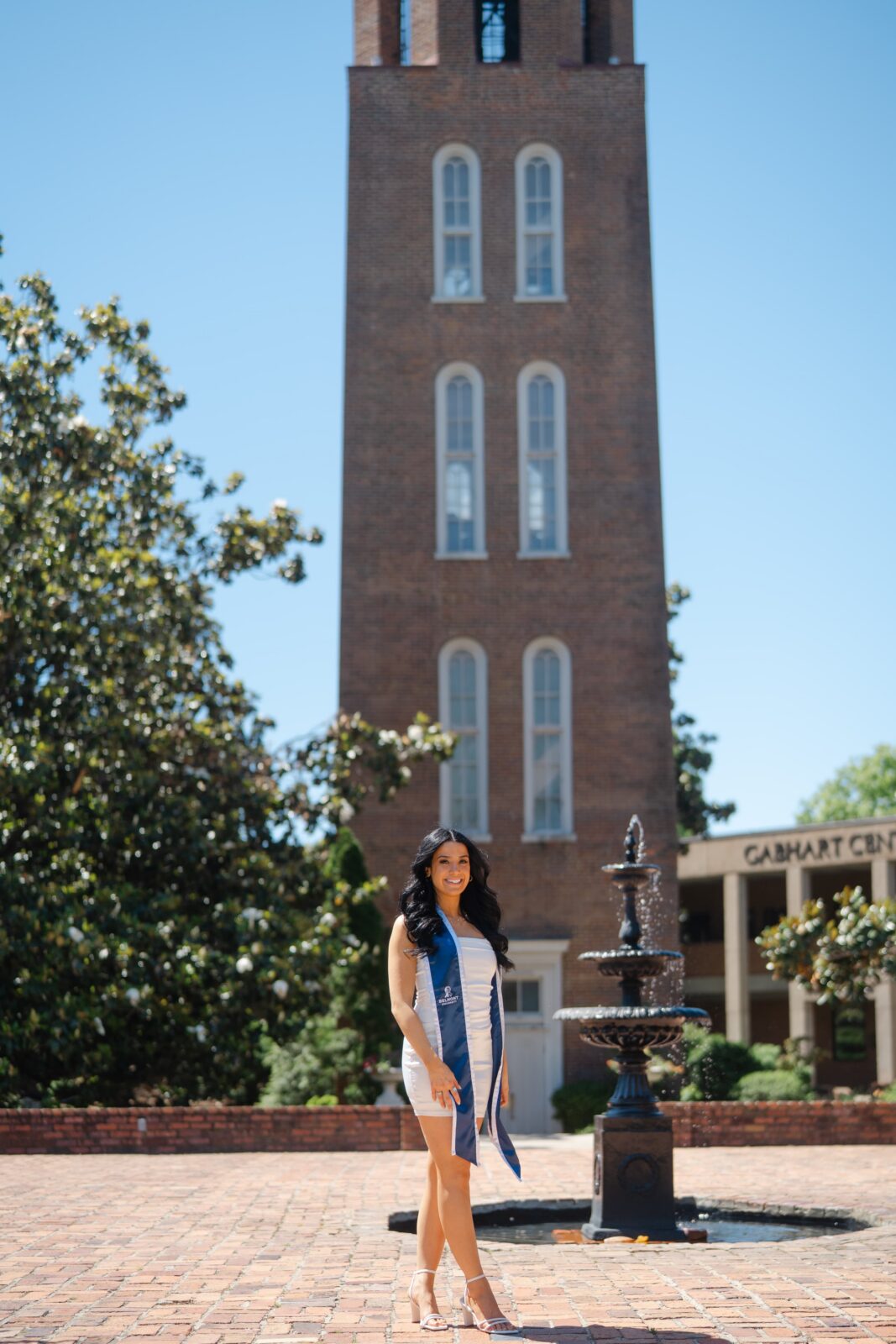 ollege graduation photos at Belmont University with a grad posed in front of the iconic bell tower and Gabhart Center fountain in Nashville TN