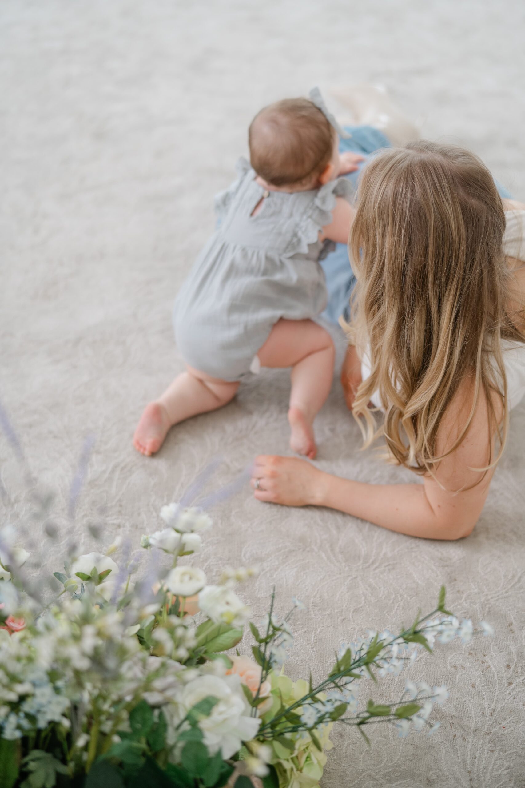 Mom and baby exploring spring florals during mommy and me photos in Nashville TN at Studio Ivoire