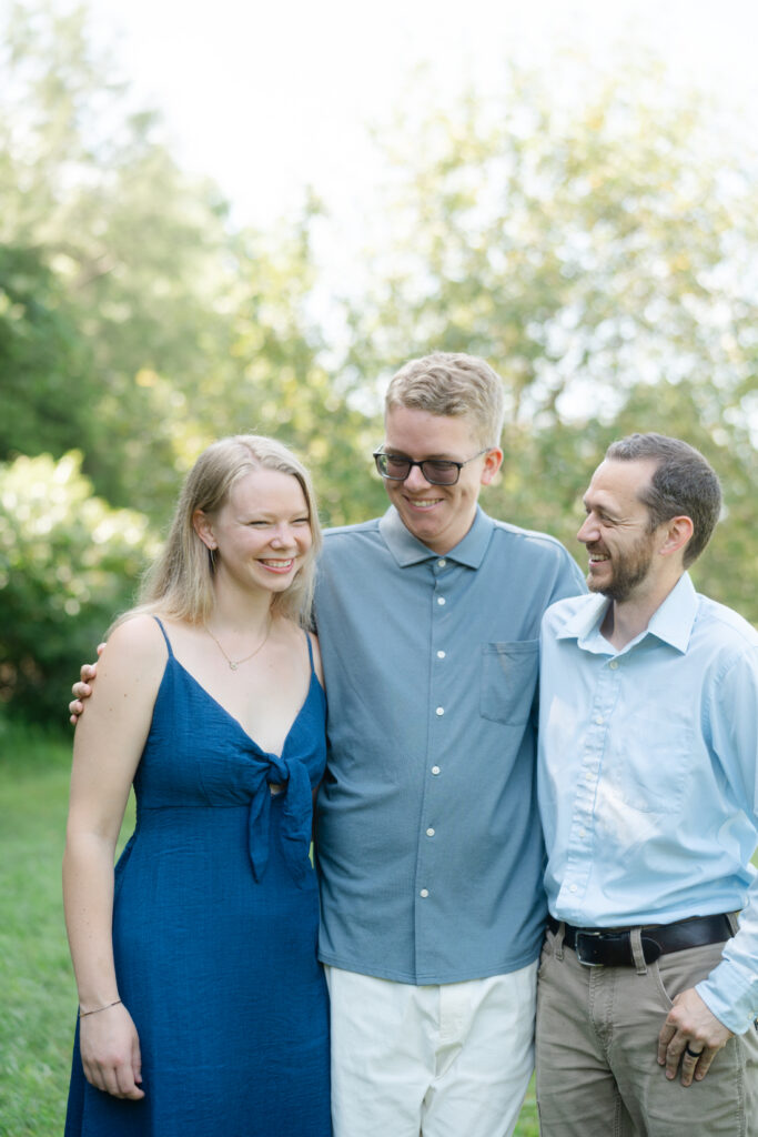 Adult siblings smiling together during their extended family photos session in Nashville.