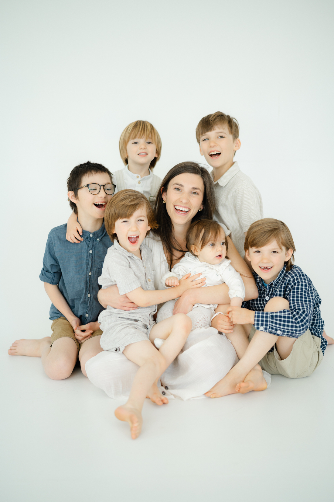Mother surrounded by her five children during a full service family photography session in Nashville studio.