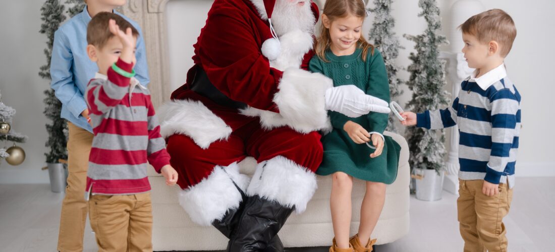 Candid moment between Santa and children at a Christmas mini session at Studio Ivoire