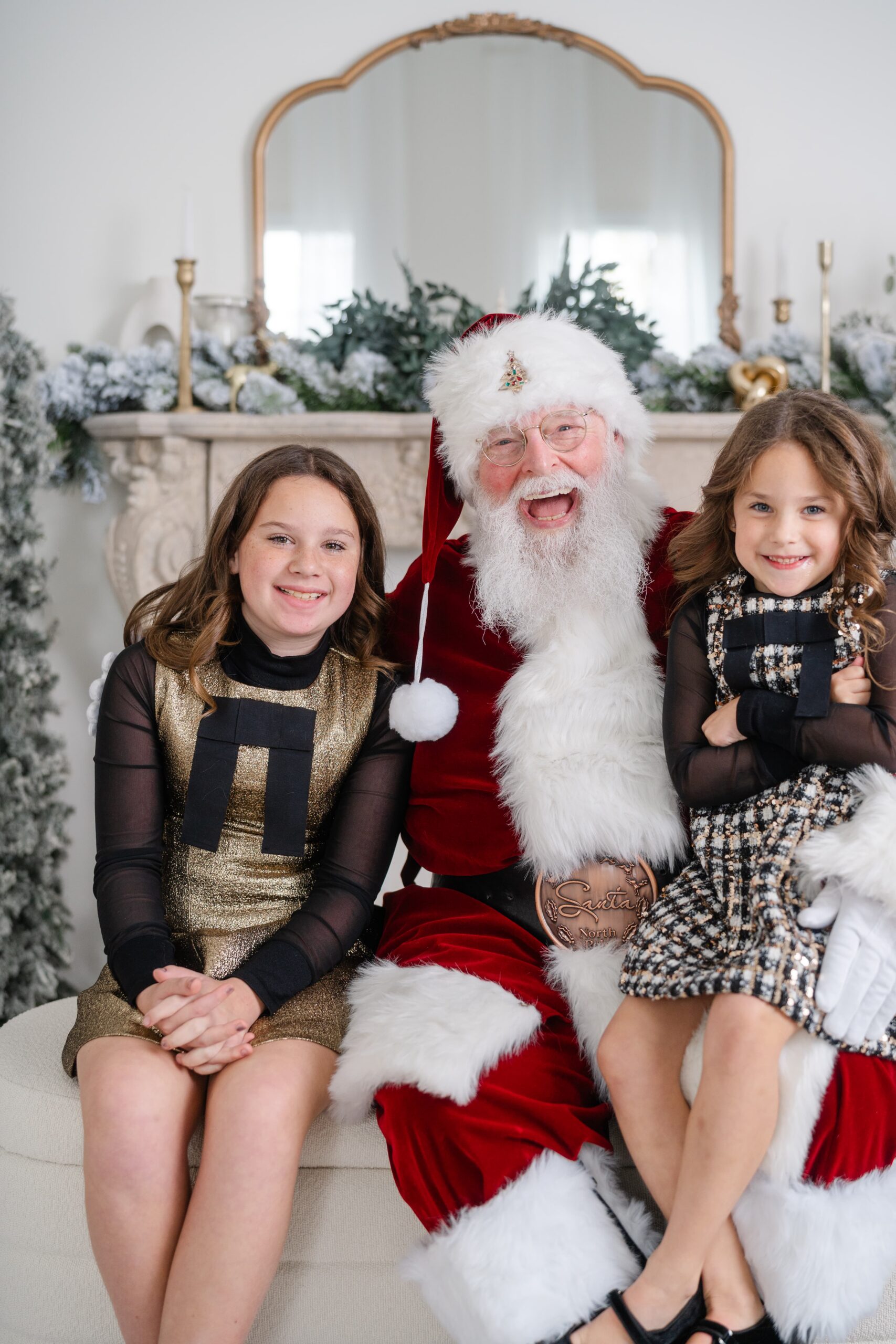 Sisters in holiday dresses posing with Santa at Studio Ivoire in Franklin Tennessee