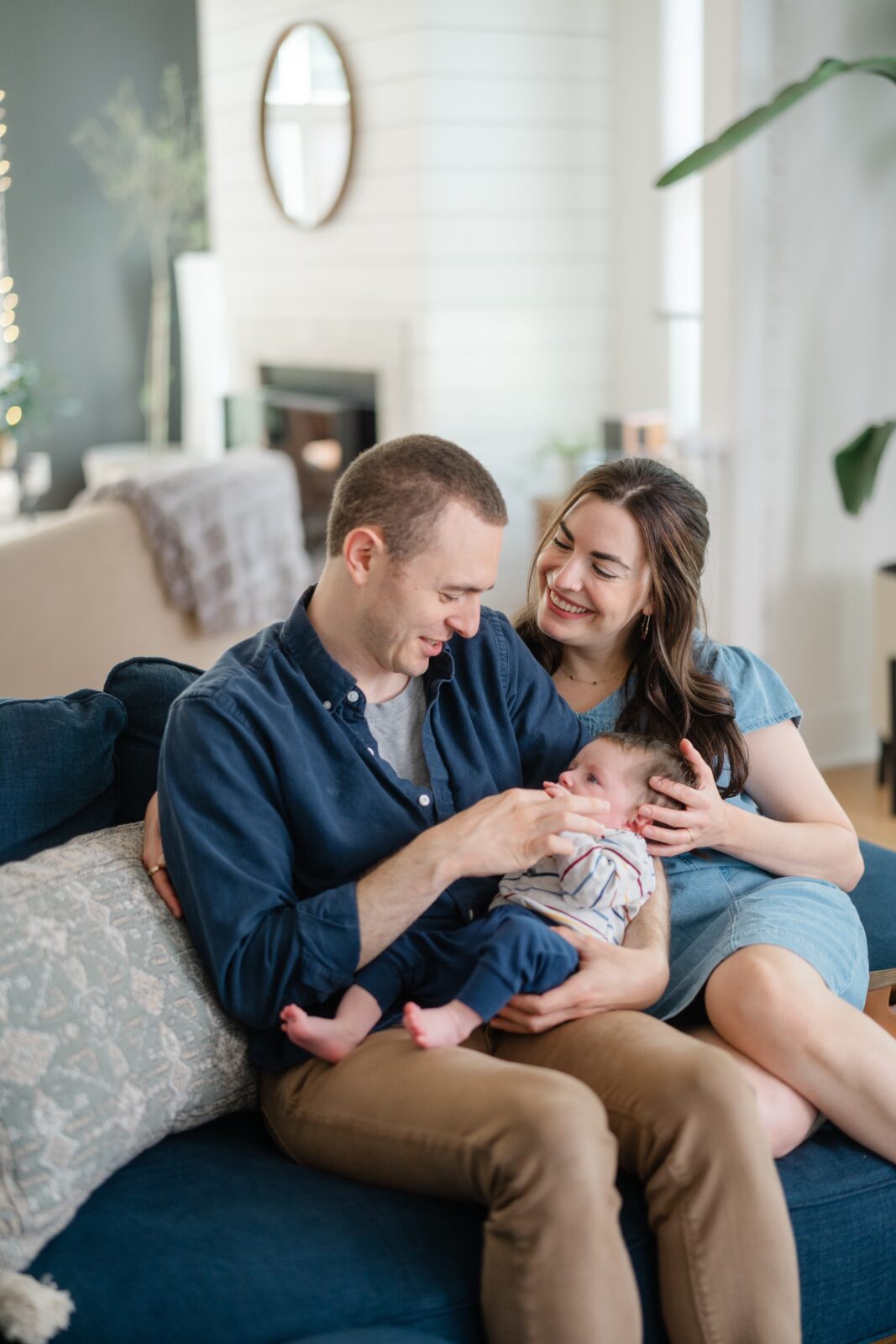 Parents holding their baby on the couch during an in home Nashville family photography session