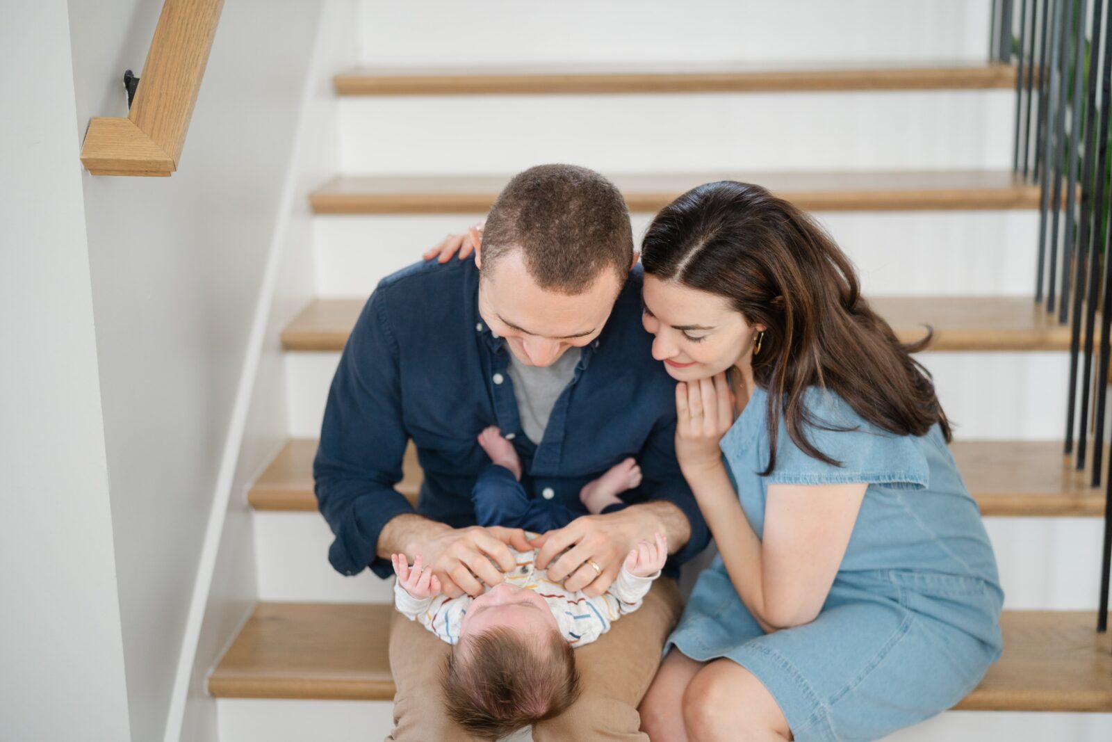 Family sitting on their staircase during an at home family photo session in Nashville Tennessee