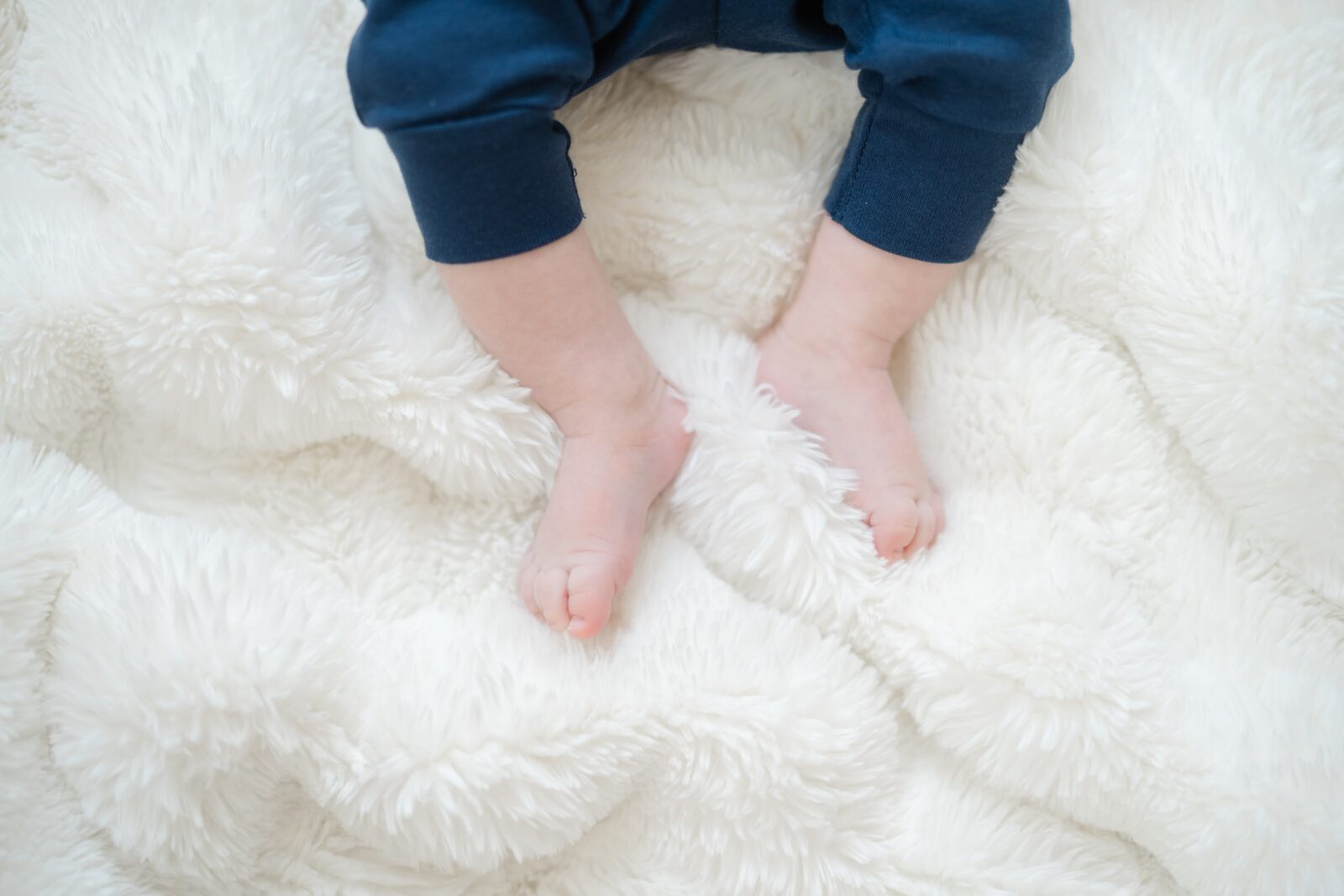 Detail of baby feet on a soft blanket captured during an in home Nashville family session