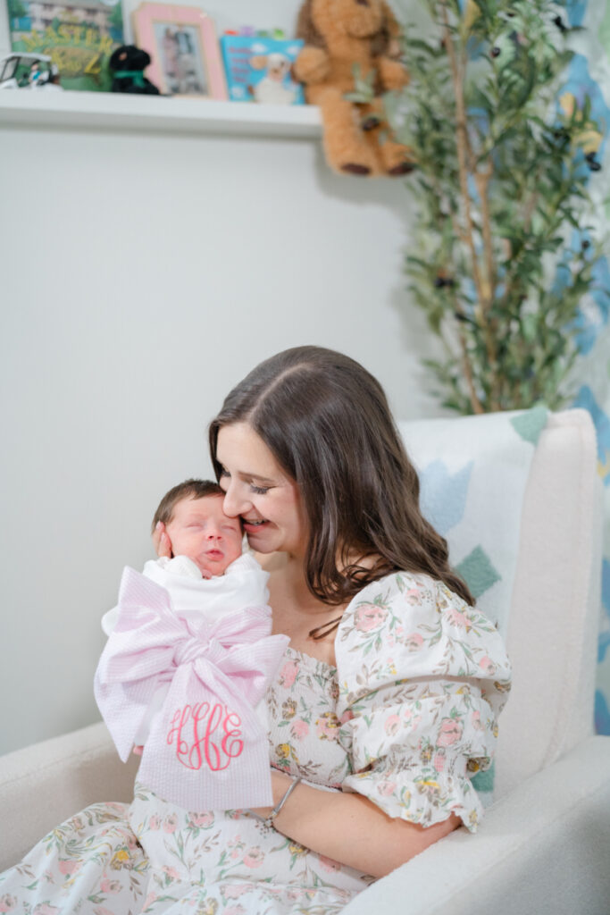 Mother cuddling her newborn during a Nashville newborn photography session in the baby's nursery.