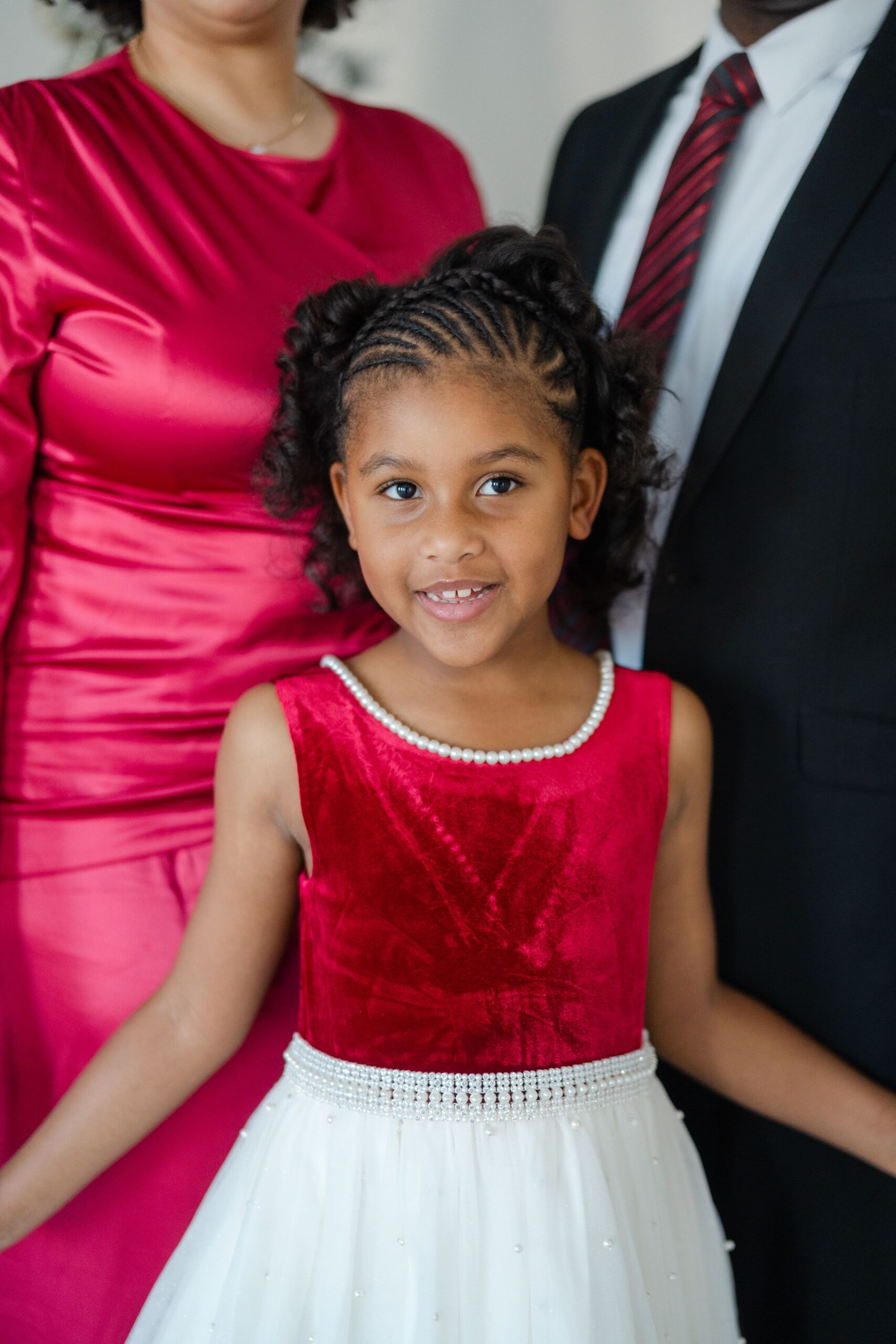 Girl in a red velvet Christmas dress with her family at a Nashville holiday portrait session