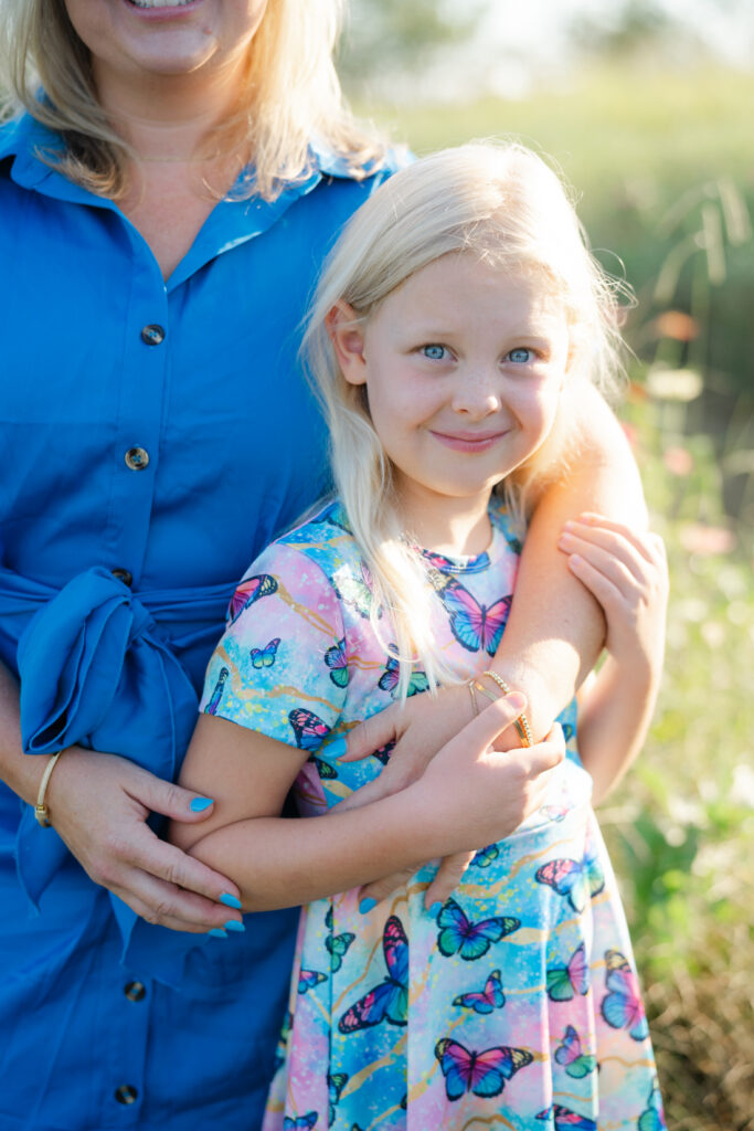 Nashville summer mini sessions featuring a mother and daughter cuddling together in a colorful flower field