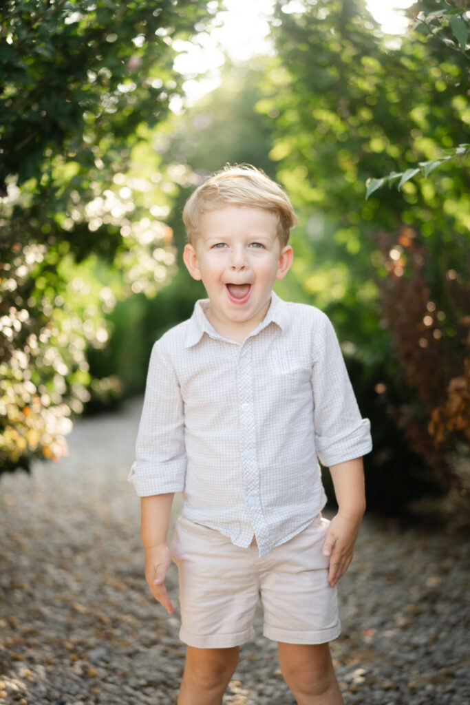 Young boy making a playful expression during an outdoor summer family photography session