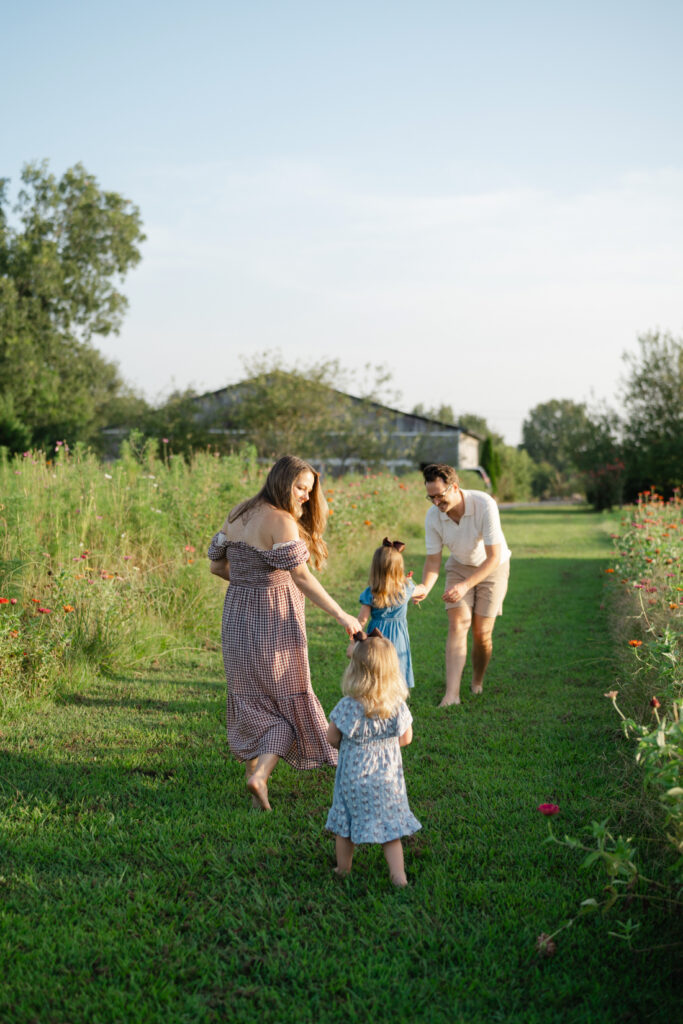 Family playing together between flower rows during Nashville summer mini sessions at Perry Family Farm