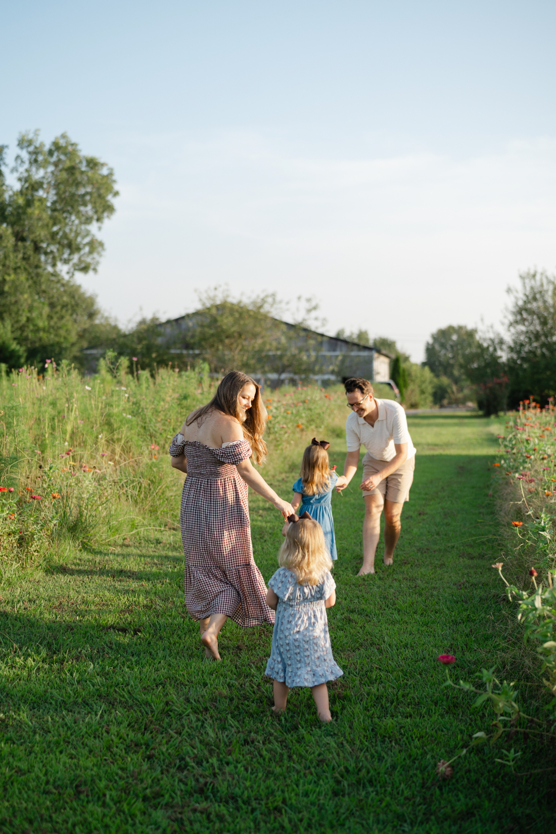 Family playing together between flower rows during Nashville summer mini sessions at Perry Family Farm